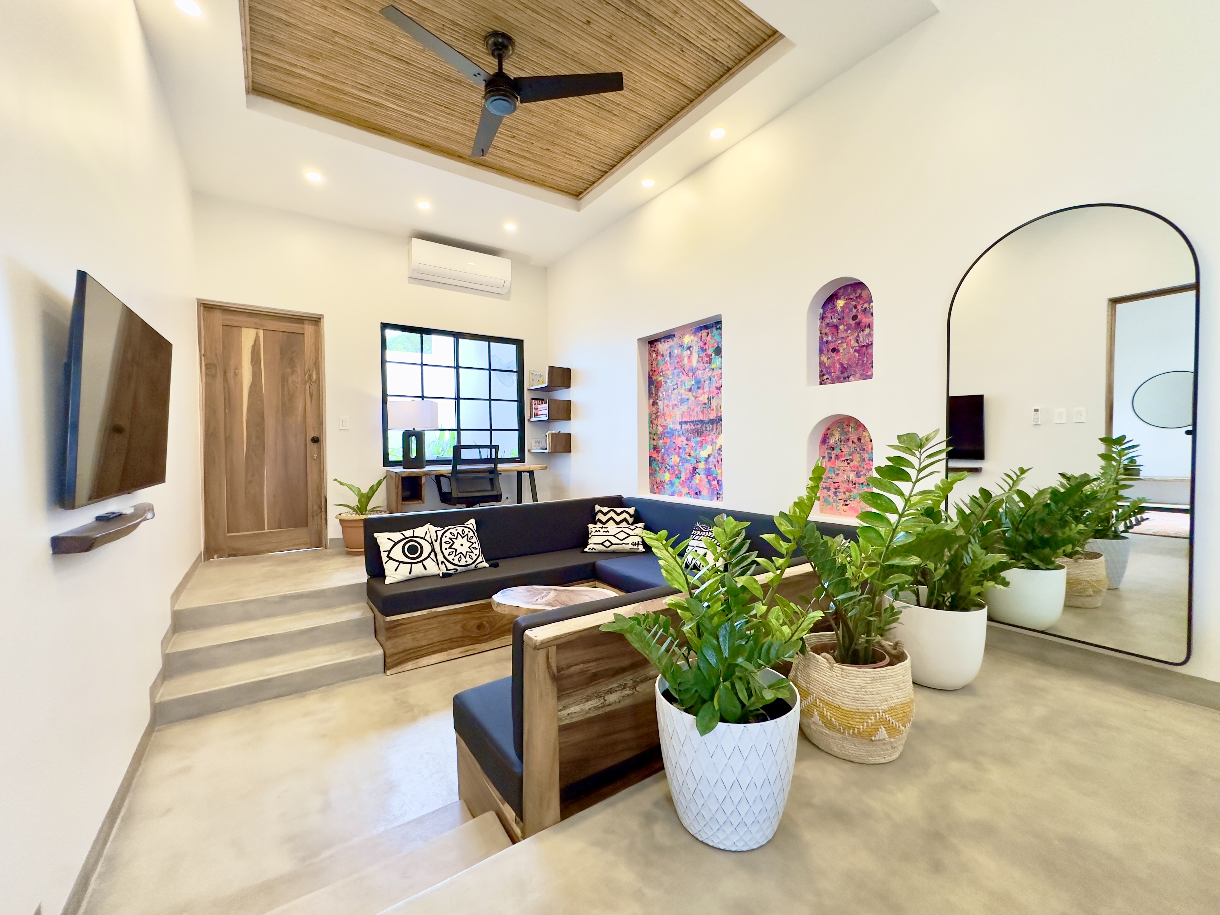 Casitas Fénix living room with a bamboo ceiling, built-in seating and indoor plants